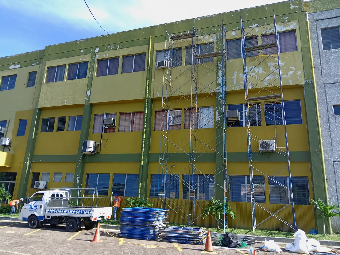 Andamios instalados en el exterior de un edificio junto a un camión de MIG