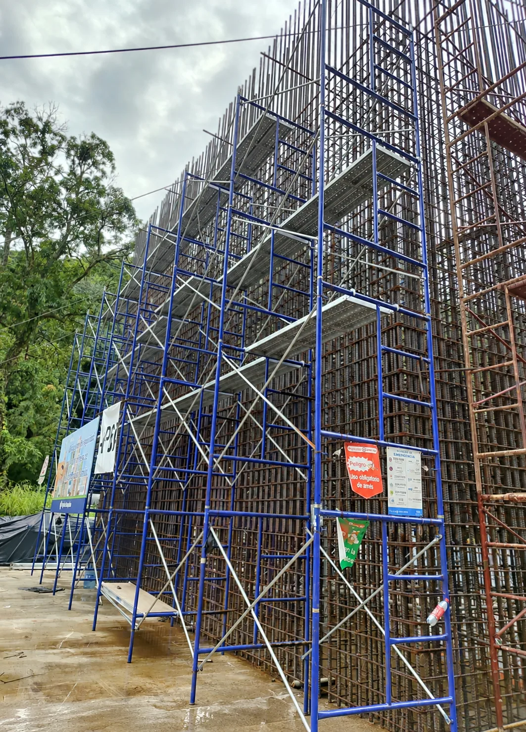 Andamio azul instalado junto a una estructura de construcción